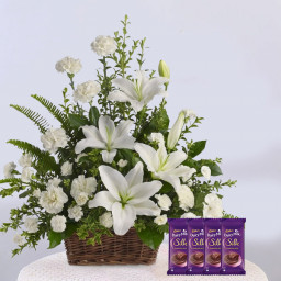 Basket of Happiness: A Gift Combo of 20 White Carnations, 4 White Lily with Basket Arrangement, and 4 Dairy Milk Silk Basket of Happiness: A Gift Combo of 20 White Carnations, 4 White Lily with Basket Arrangement, and 4 Dairy Milk Silk